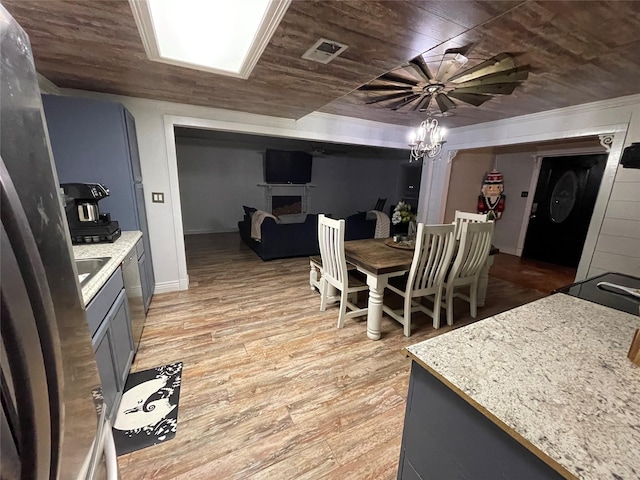 dining space featuring a notable chandelier, wood ceiling, light hardwood / wood-style floors, and sink