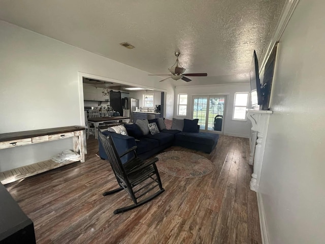 living room featuring ceiling fan, hardwood / wood-style floors, and a textured ceiling