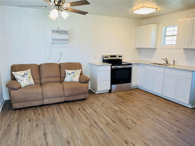 living room featuring sink, an AC wall unit, light wood-type flooring, ornamental molding, and ceiling fan