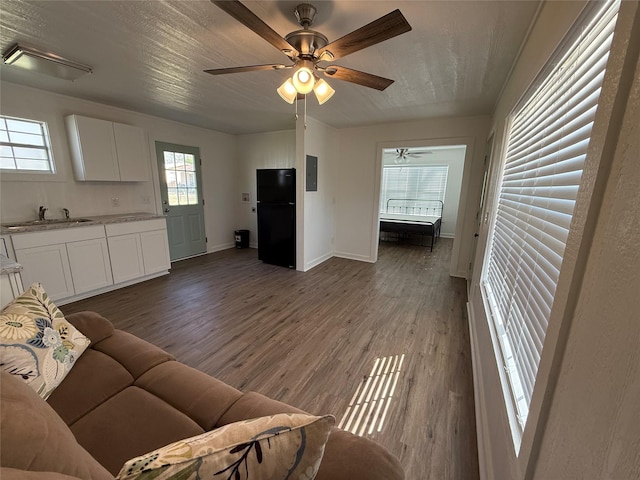 living room featuring sink, hardwood / wood-style floors, electric panel, and ceiling fan