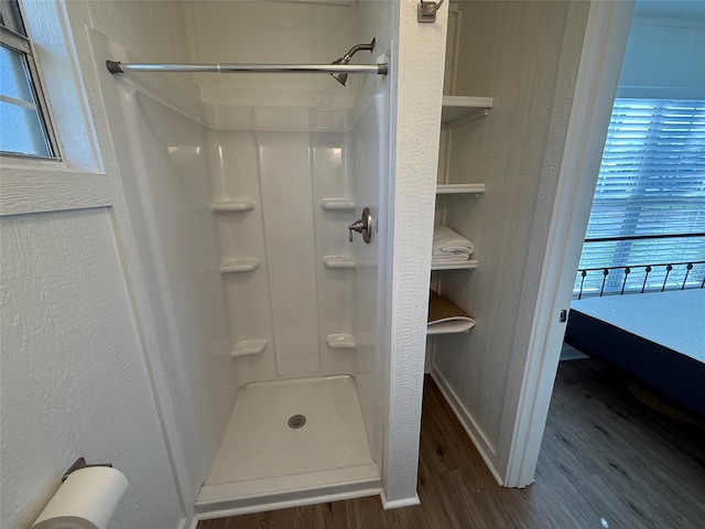 bathroom with hardwood / wood-style flooring and walk in shower