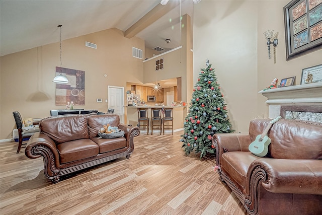 living room featuring beam ceiling, light hardwood / wood-style floors, and high vaulted ceiling