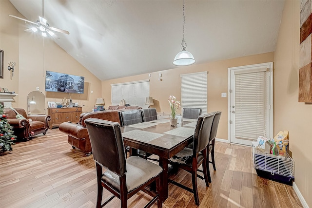 dining space featuring ceiling fan, high vaulted ceiling, and light wood-type flooring