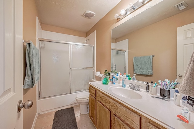 full bathroom featuring tile patterned floors, vanity, toilet, and shower / bath combination with glass door