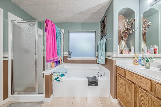 bathroom featuring tile patterned flooring, vanity, a textured ceiling, and separate shower and tub