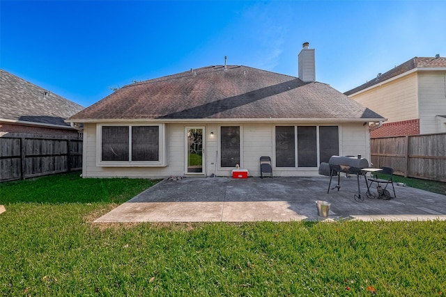 rear view of house with a yard and a patio