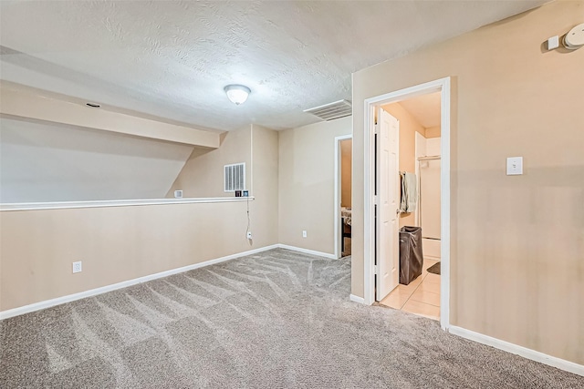 interior space featuring light colored carpet, lofted ceiling, and a textured ceiling