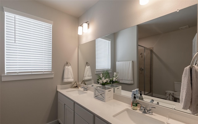 bathroom featuring vanity, toilet, and a shower with shower door