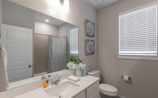 bathroom with curtained shower, vanity, and toilet