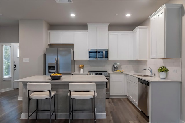 kitchen featuring white cabinetry, sink, a kitchen island, and stainless steel appliances