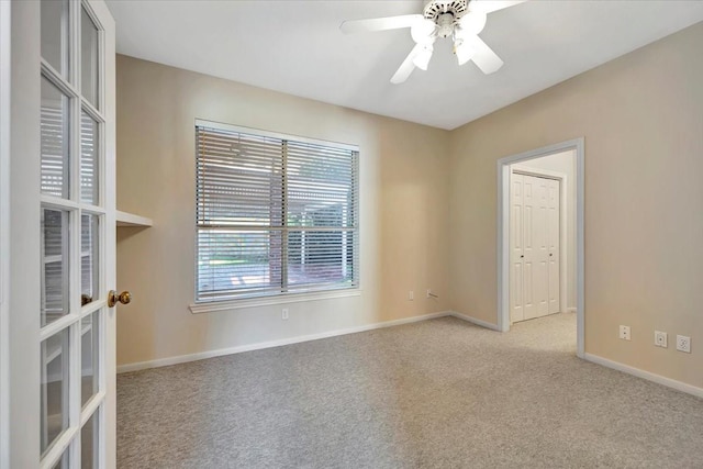 carpeted spare room featuring ceiling fan