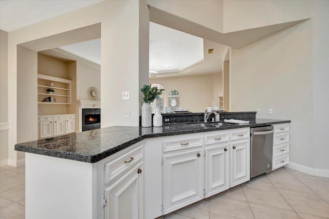 kitchen featuring kitchen peninsula, built in shelves, sink, dishwasher, and white cabinets