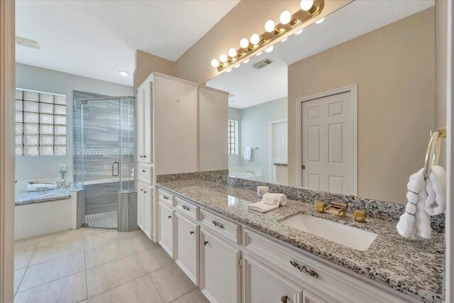 bathroom featuring tile patterned floors, plenty of natural light, vanity, and independent shower and bath