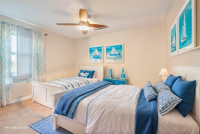 bedroom featuring light carpet, ceiling fan, and baseboards