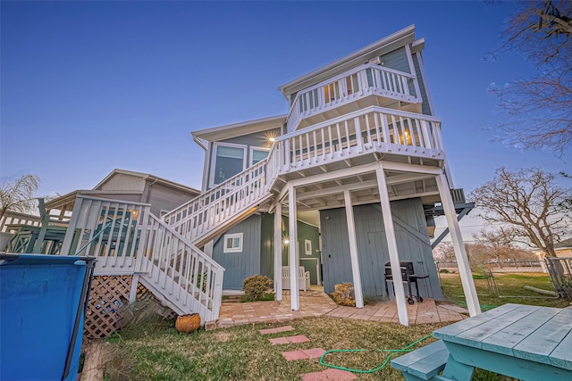 rear view of house featuring a patio area and stairway