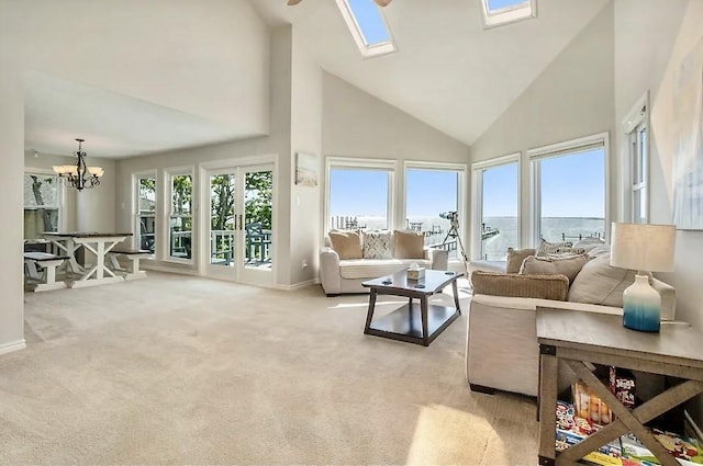 living room with a skylight, a water view, plenty of natural light, and light carpet