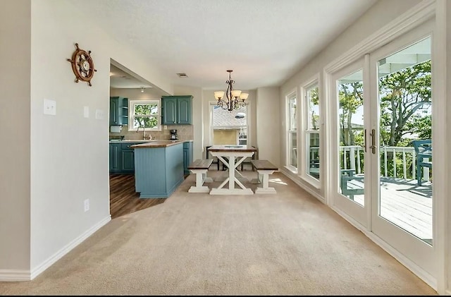 dining area featuring light carpet, plenty of natural light, visible vents, and a chandelier