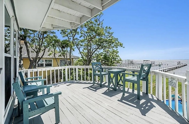 wooden deck with a water view and a fenced in pool