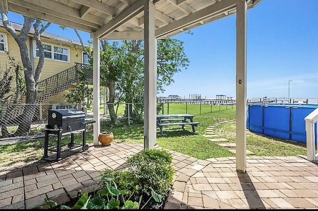 view of patio / terrace with stairs, grilling area, fence, and an outdoor pool