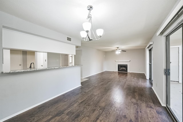 unfurnished living room featuring sink, ceiling fan with notable chandelier, and dark hardwood / wood-style floors