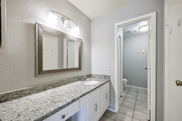 bathroom with tile patterned flooring, vanity, and toilet