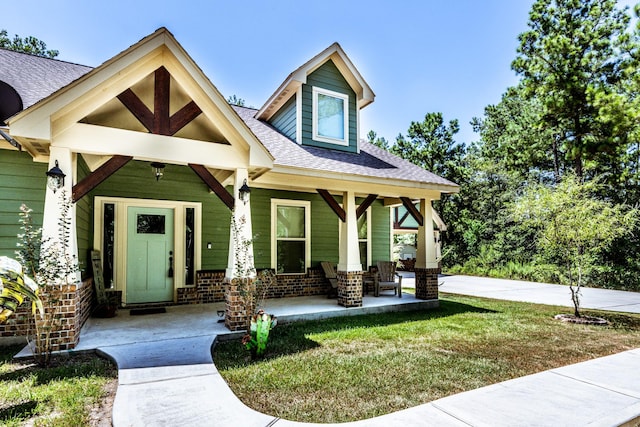 craftsman-style home featuring covered porch and a front yard