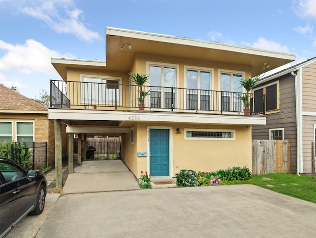 rear view of house featuring a carport and a balcony