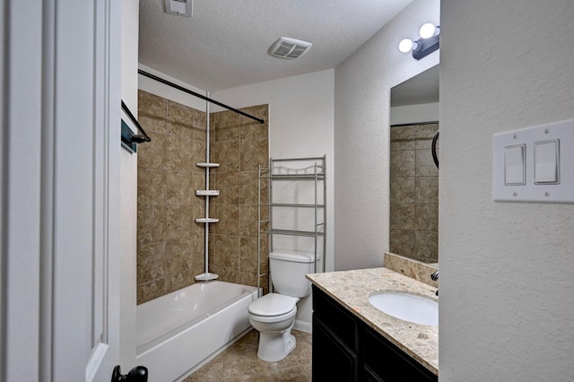 full bathroom featuring vanity, toilet, a textured ceiling, and tiled shower / bath