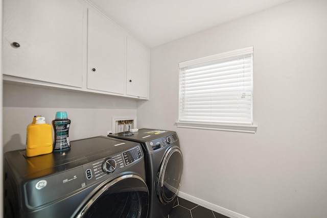 laundry room with cabinets, separate washer and dryer, and dark tile patterned floors