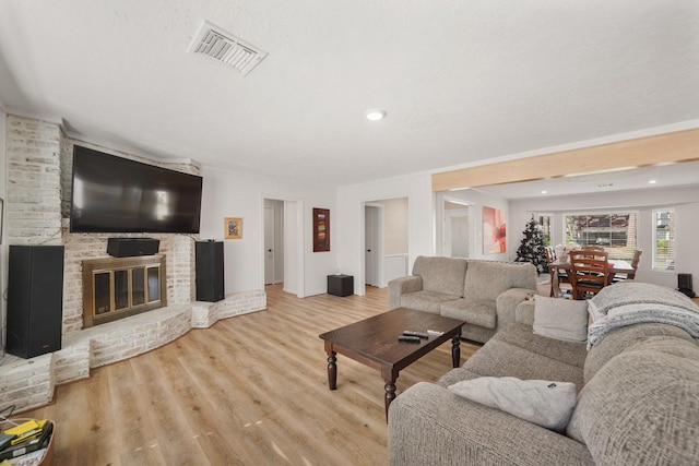 living room with a fireplace and light wood-type flooring