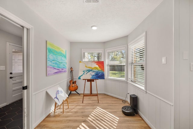 living area with a textured ceiling and light wood-type flooring