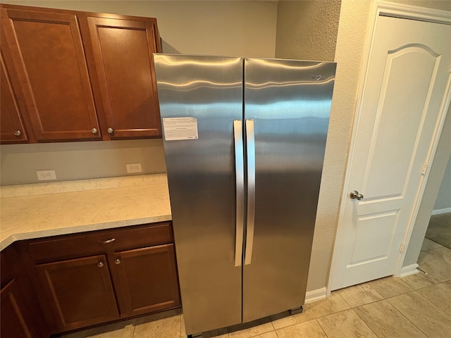 kitchen featuring stainless steel fridge and light tile patterned flooring