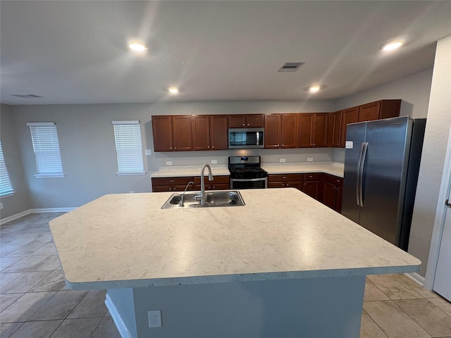 kitchen featuring a center island with sink, light tile patterned flooring, sink, and stainless steel appliances