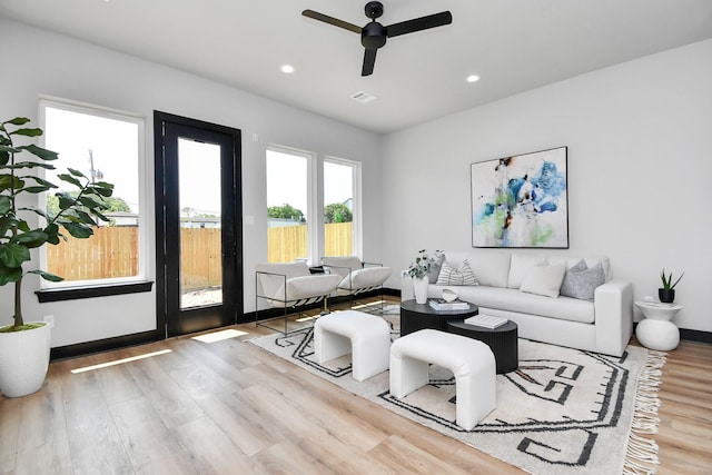 living room with light hardwood / wood-style flooring and ceiling fan