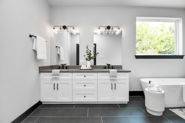 bathroom featuring tile patterned flooring, vanity, and a tub to relax in