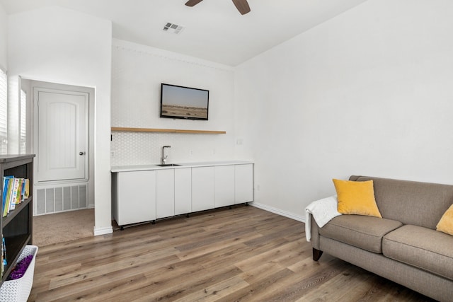 living room with ceiling fan, sink, and hardwood / wood-style flooring