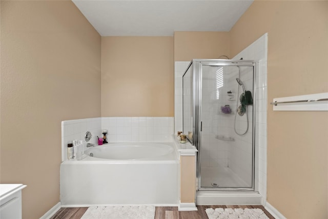 16507 Cypress Brook Ct, Cypress, TX 77429 - bathroom featuring a shower stall, a garden tub, wood finished floors, and baseboards