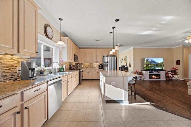 16507 Cypress Brook Ct, Cypress, TX 77429 - kitchen with stainless steel appliances, a sink, light brown cabinetry, tasteful backsplash, and open floor plan