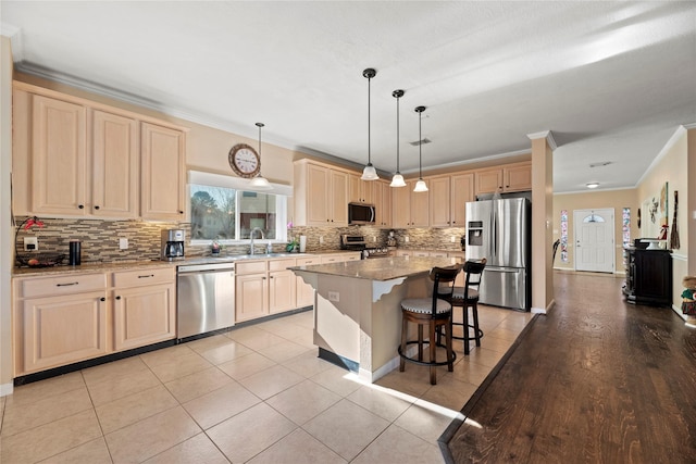 16507 Cypress Brook Ct, Cypress, TX 77429 - kitchen featuring stainless steel appliances, ornamental molding, light brown cabinetry, tasteful backsplash, and a kitchen bar