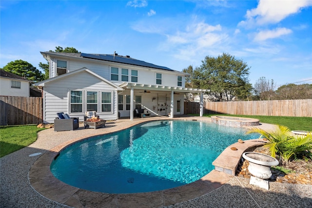 16507 Cypress Brook Ct, Cypress, TX 77429 - rear view of house with a fire pit, solar panels, a fenced backyard, and an in-ground hot tub