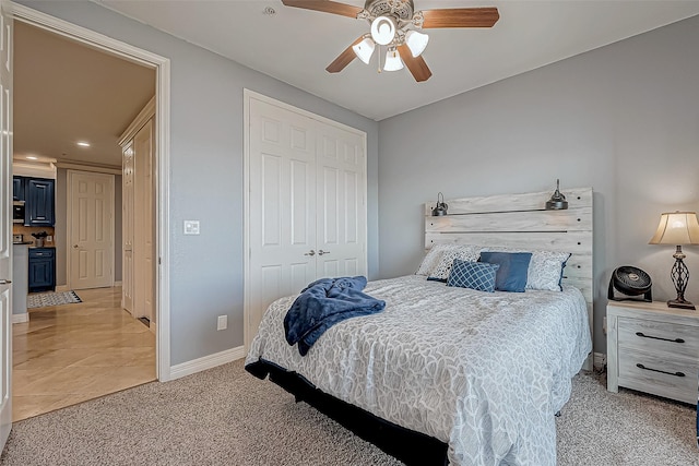 carpeted bedroom with ceiling fan and a closet