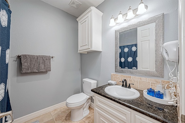 bathroom featuring decorative backsplash, tile patterned flooring, vanity, and toilet