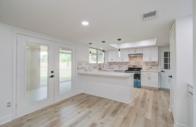 kitchen featuring kitchen peninsula, french doors, stainless steel electric range oven, white cabinetry, and hanging light fixtures