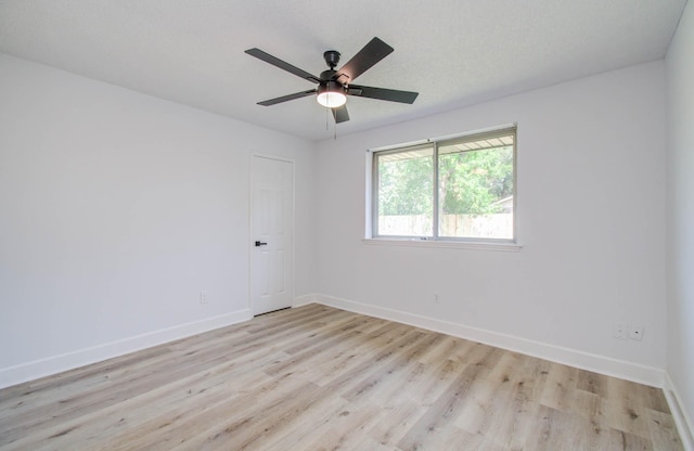 empty room featuring ceiling fan, light wood-type flooring, and a textured ceiling