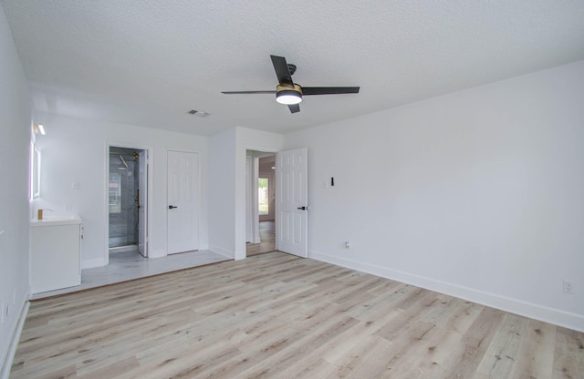 empty room with ceiling fan, sink, light hardwood / wood-style floors, and a textured ceiling