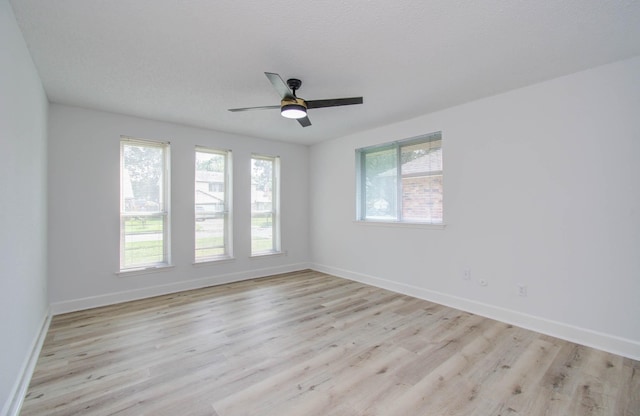 empty room featuring ceiling fan, light hardwood / wood-style flooring, and a textured ceiling