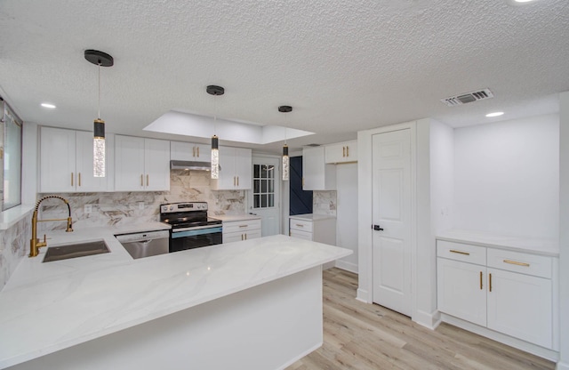 kitchen with kitchen peninsula, appliances with stainless steel finishes, sink, white cabinetry, and hanging light fixtures