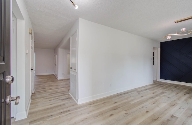 foyer entrance with a textured ceiling and light wood-type flooring