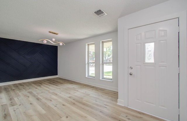 foyer with a textured ceiling and light wood-type flooring