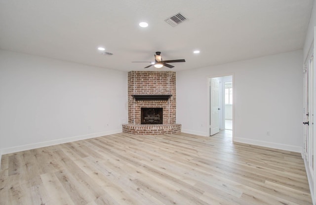 unfurnished living room with ceiling fan, a fireplace, and light hardwood / wood-style flooring